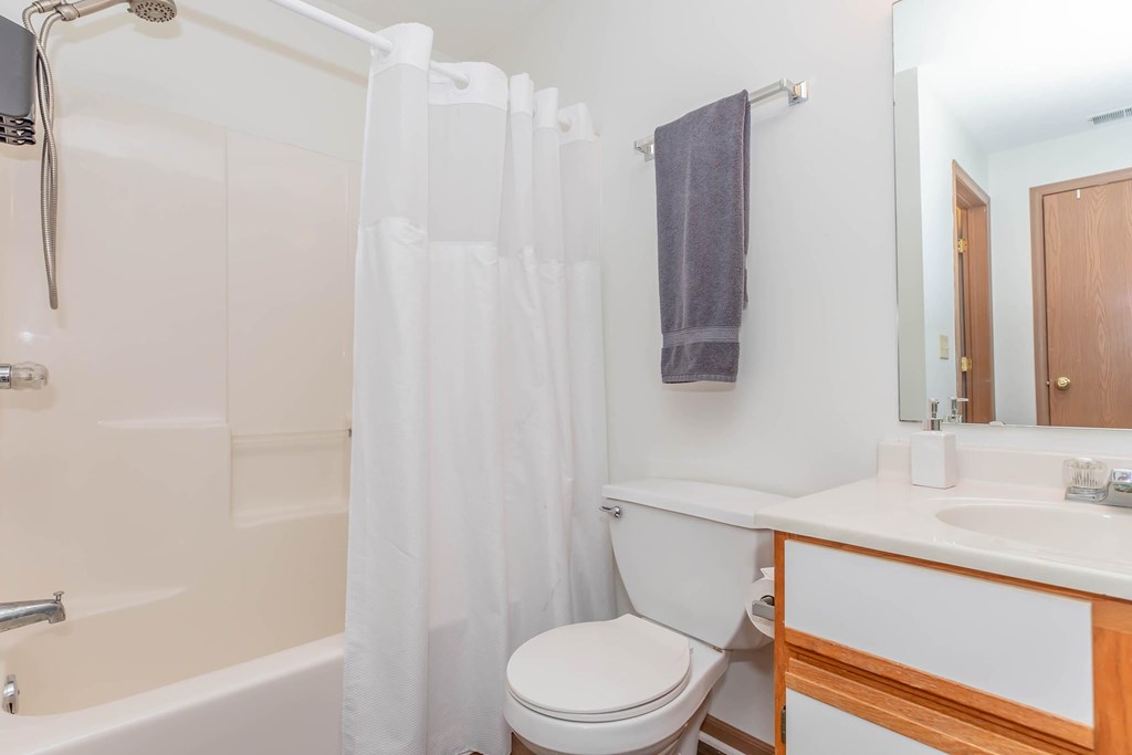 A white bathroom with a toilet, sink, and bathtub.
