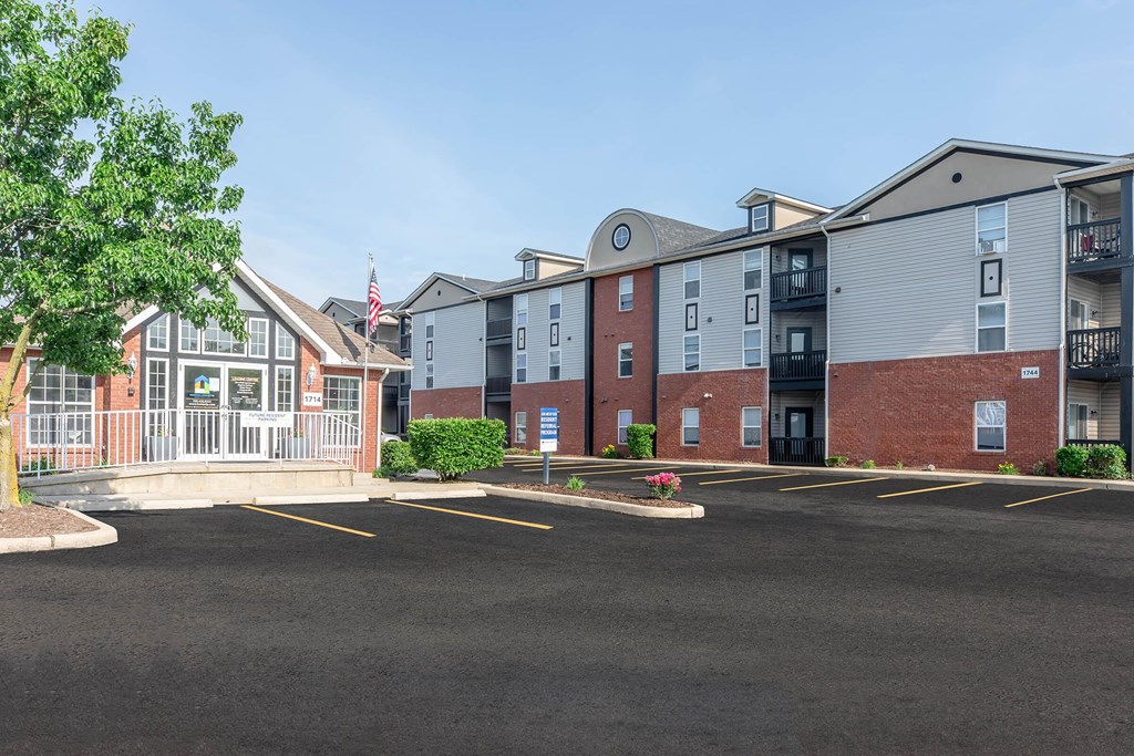 A parking lot in front of a building with a flag on it.