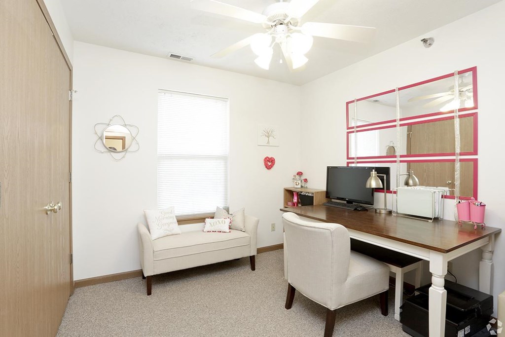 A room with a desk, chair, and a window.