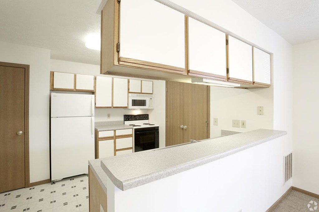 A kitchen with white appliances and a white counter top.