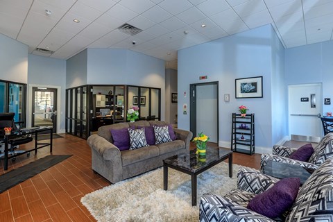 A living room with a grey couch and a black coffee table.