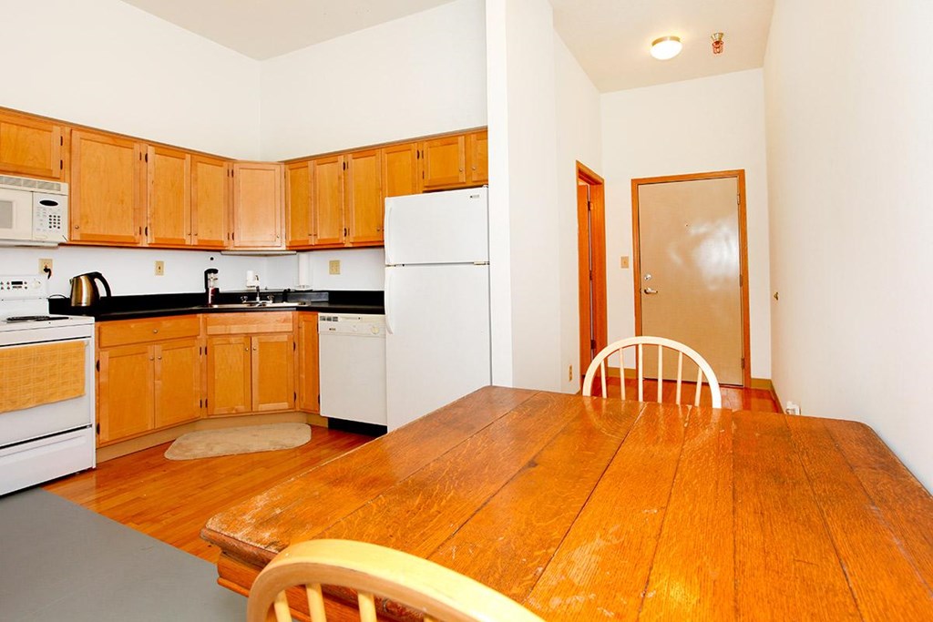 A kitchen with wooden cabinets and a white refrigerator.