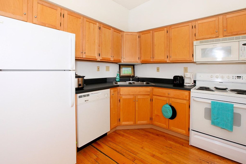 A kitchen with wooden cabinets and white appliances.