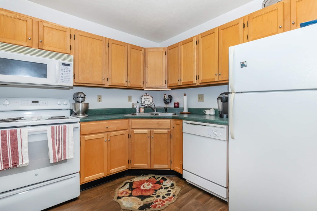 A kitchen with wooden cabinets and white appliances.