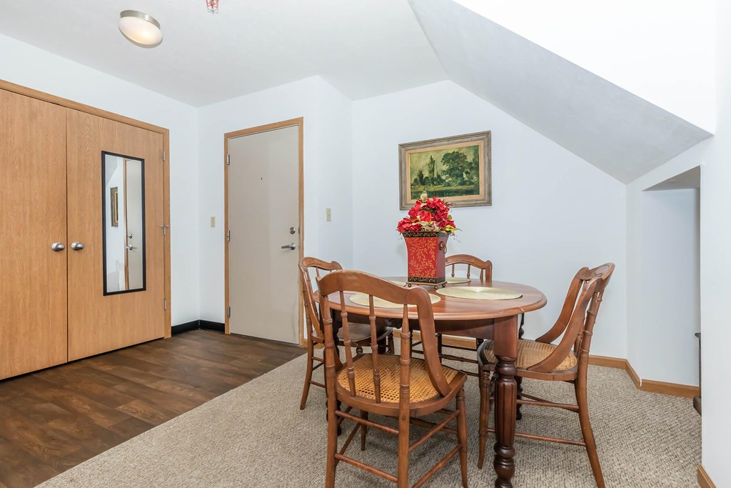 A dining room with a wooden table and chairs.