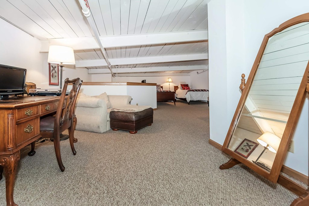 A room with a wooden desk and a mirror on the wall.