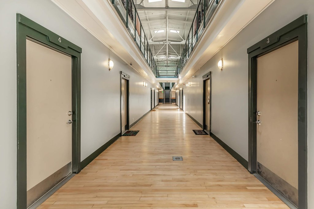 A long hallway with doors on both sides and a skylight above.