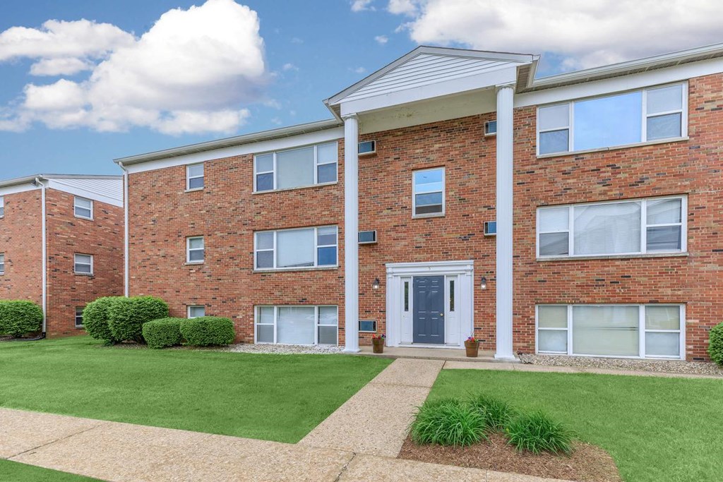 A red brick apartment building with a white door and windows.