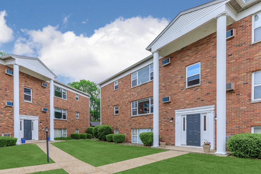 A row of red brick apartment buildings with white trim and doors.