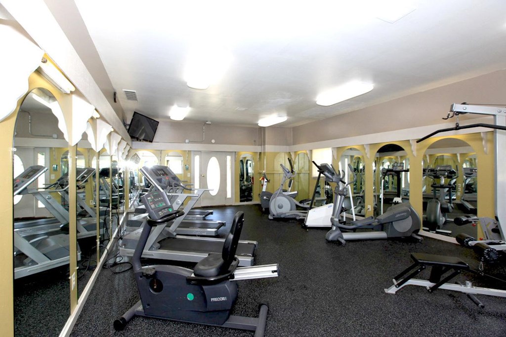 A gym with treadmills, elliptical machines, and other exercise equipment.
