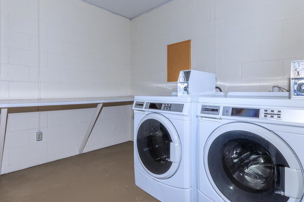 Two front load washing machines in a laundry room.