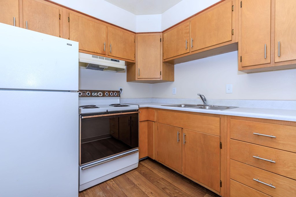 A kitchen with wooden cabinets and a white refrigerator.
