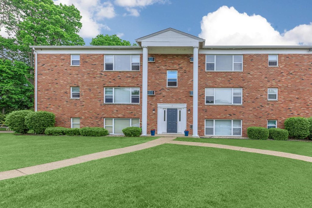 A red brick building with a white door and windows.