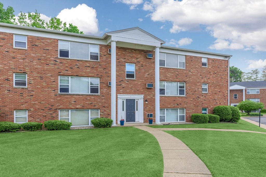 A red brick building with a white door and windows.