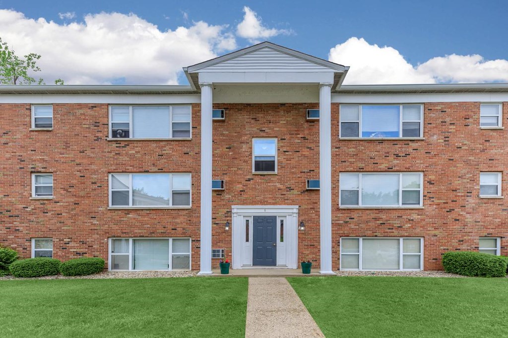 A red brick building with a white door and windows.