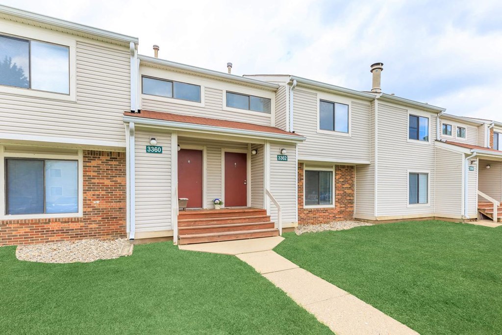 A row of houses with a red door in the middle.