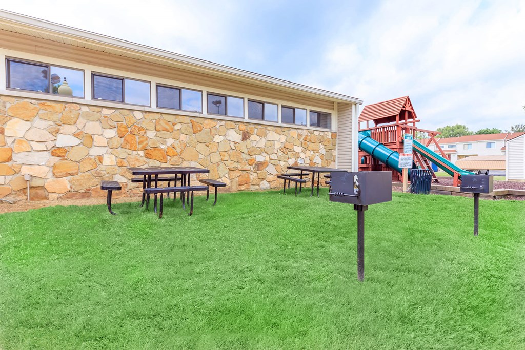 A playground with a slide and a picnic table.