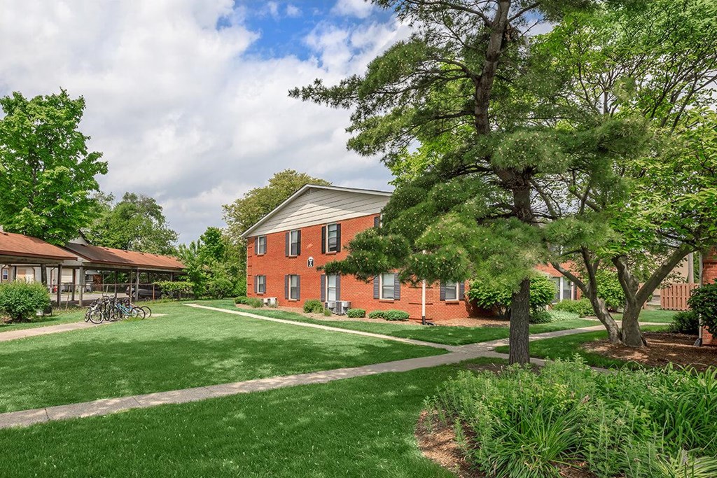A red brick building with a green lawn in front.