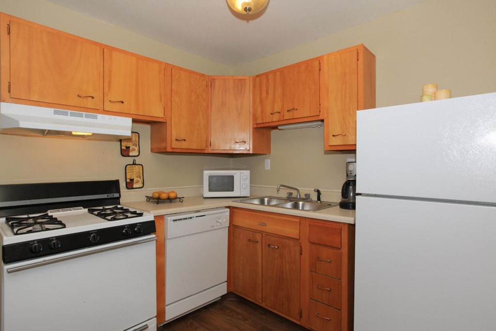 A kitchen with wooden cabinets and white appliances.