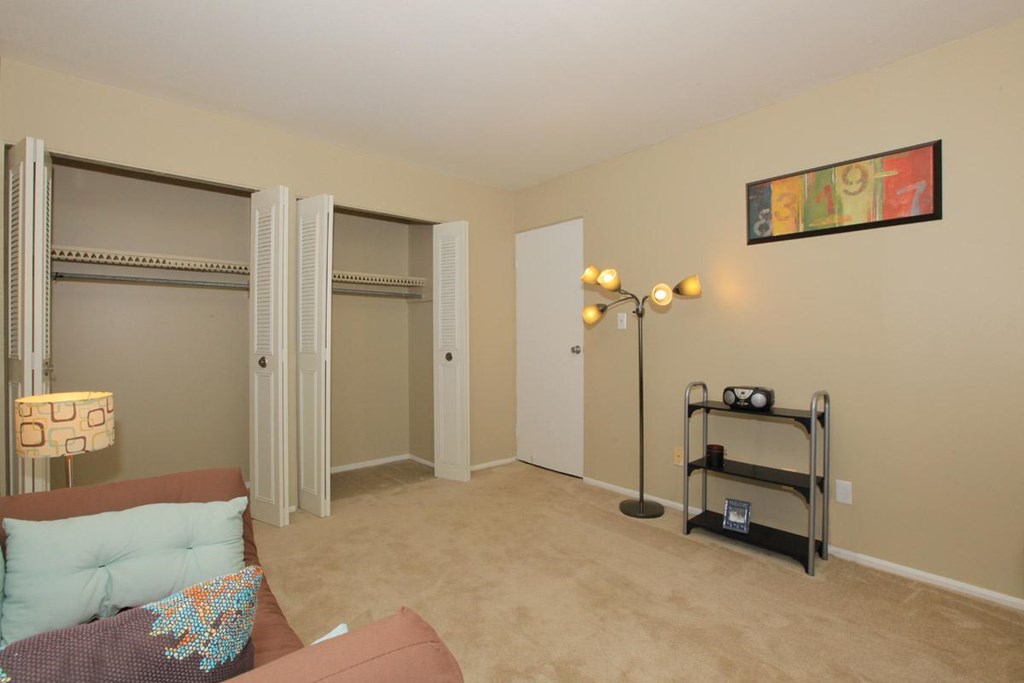 A living room with a couch, a chair, a lamp, and a picture on the wall.