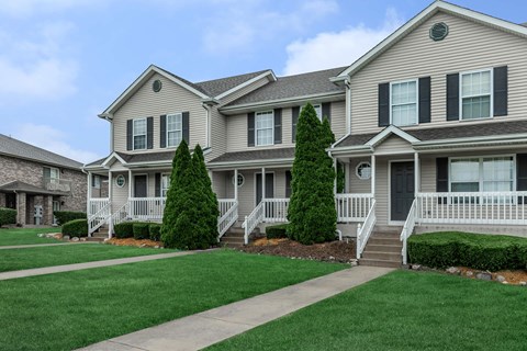 A row of houses with green lawns in front.