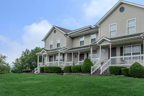 A large, two-story house with a front porch and a well-manicured lawn.