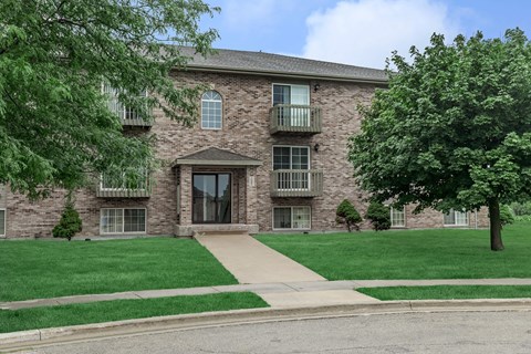 A brick building with a tree in front.