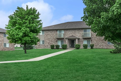 A large building with a green lawn in front.