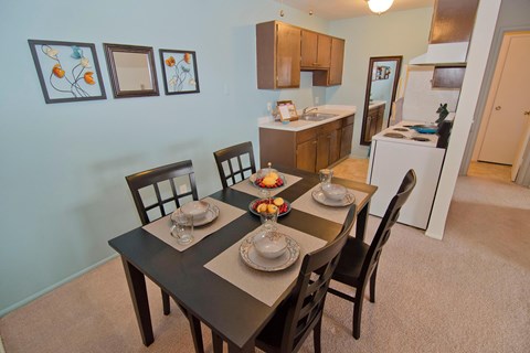 A dining room with a table set for two.
