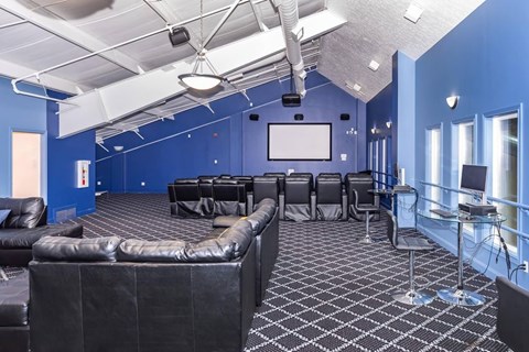 A room with a black couch and a white screen.