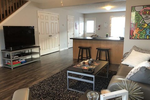 A living room with a black coffee table and a TV on a stand.
