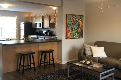 A kitchen with a bar and a painting on the wall.