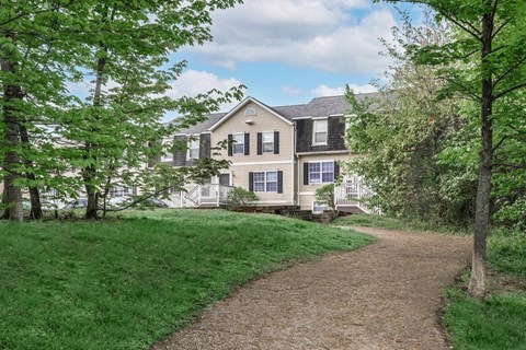 A house with a white fence and a gravel path leading to it.
