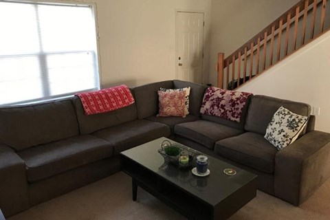 A living room with a grey sectional sofa and a coffee table.