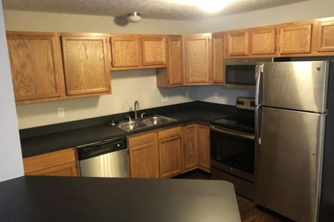 A kitchen with wooden cabinets and a black countertop.