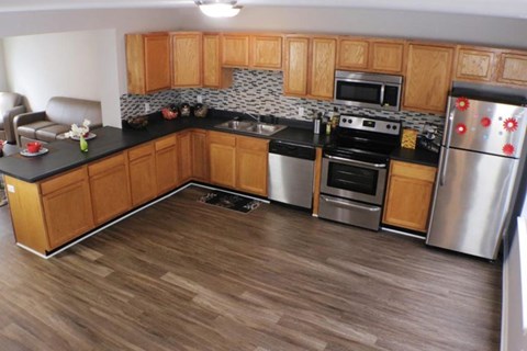 A kitchen with wooden cabinets and a black countertop.