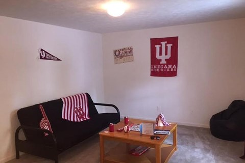 A room with a couch, a chair, a coffee table and a wall hanging.