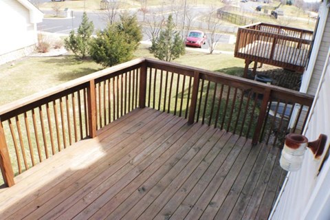A wooden deck with a white railing and a lantern on the right side.
