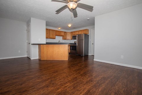 A kitchen with wooden floors and a ceiling fan.