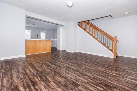 A room with wooden floors and a staircase.