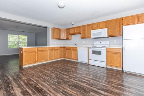 A kitchen with wooden cabinets and white appliances.
