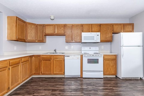 A kitchen with wooden cabinets and white appliances.