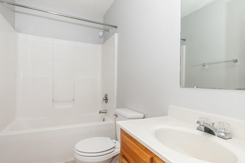 A white toilet sits next to a white sink in a bathroom.