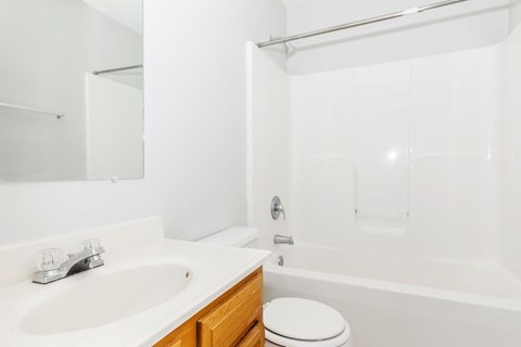 A white bathroom with a sink, toilet and bathtub.
