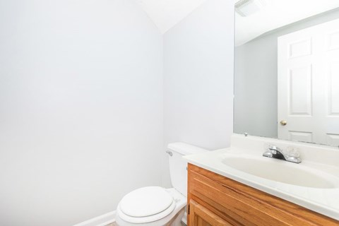 A white toilet sits next to a sink in a bathroom.