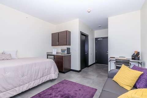 A bedroom with a bed, a couch, and a cabinet.