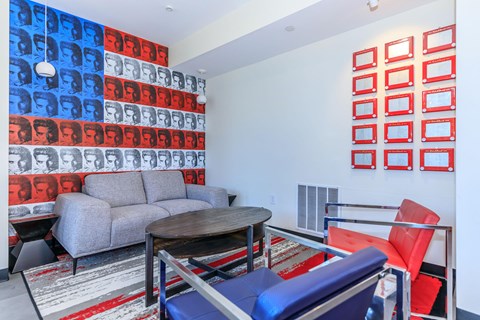 A living room with a grey couch, a red chair, and a table.