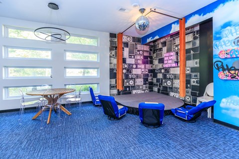A room with a blue carpet and a wooden table with chairs.