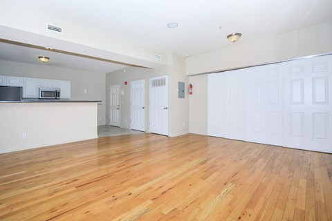 A large empty room with wooden floors and white walls.