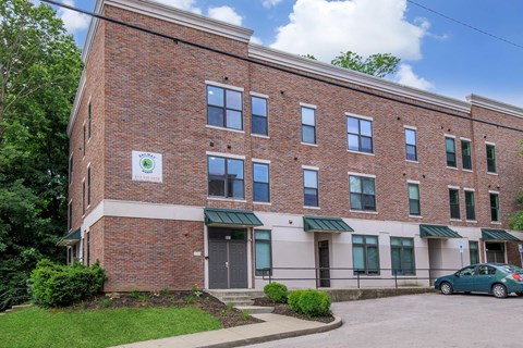 A brick building with a green awning and a sign on the front.
